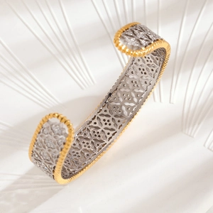 Macro view of gold-silver hollowed honeycomb pattern and beaded edges on open bangle