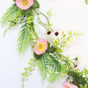 Close-up of pink cosmos and white daisies with green fern leaves on a wedding arch floral
