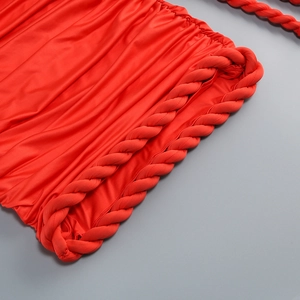 Detail of red off-shoulder dress featuring ruched fabric and chunky twist rope decoration