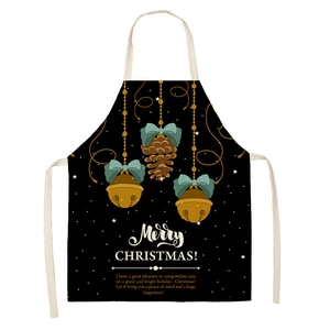 Close-up of black Christmas linen apron with Merry Christmas greeting and festive holiday pattern