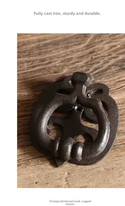 Close-up of retro cast iron door knocker in dark bronze finish on a rustic wood surface