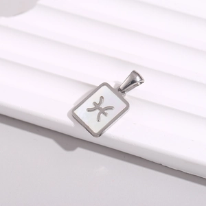 Macro detail of a silver rectangular Pisces constellation pendant with white shell inlay