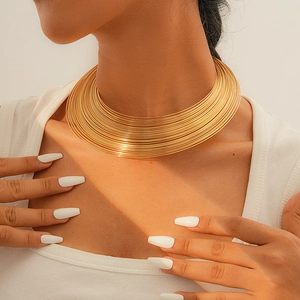 Detailansicht eines minimalistischen goldfarbenen mehrlagigen Halsreifs am Hals des Models