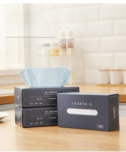 Macro shot of the dispenser box and light blue microfiber cleaning cloths on a wooden counter