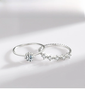 Close-up detail of silver S925 rings with classic solitaire and curved zircon band