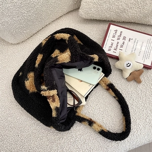 Interior view of leopard print plush tote bag showing books, phone and accessories