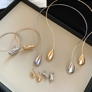 Macro shot of gold and silver teardrop jewelry set inside a luxury gift box