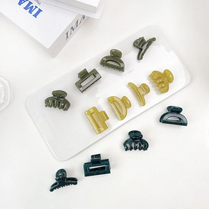 Close-up of assorted mini jelly hair claws in green and yellow on a white tray