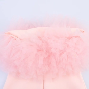 Dettaglio di volant in tulle rosa a balze e trama di tessuto liscio su un mini abito