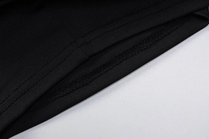 Close-up of high-quality sewing stitches and edge overlocking on black V-neck slim top