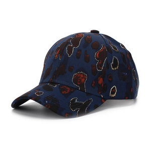 Close-up of baseball cap with red-brown pattern and gold glitter details on navy fabric