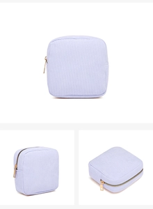 Detailed views of a light blue corduroy mini makeup bag with a gold metal zipper