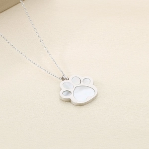 Close-up of silver cat paw pendant with iridescent mother of pearl inlay on a fine chain