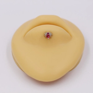 Detail of silver spider labret piercing with a pink heart stone on a silicone lip model