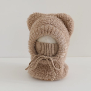 Detail of plush brown bear ear balaclava hat with integrated mask and knitted ties