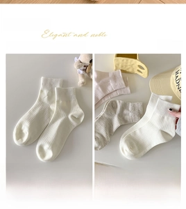 Close-up of ribbed cotton crew socks in cream white featuring vertical stripe knit texture