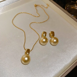 Détail du collier à chaîne torsadée plaqué or 18K et boucles d'oreilles perles assorties