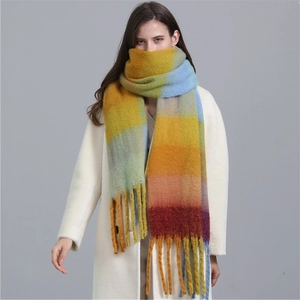 Détail d'une écharpe dégradée jaune et bleue avec franges épaisses et texture cachemire