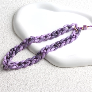 Close-up of purple acrylic phone strap with marble texture on ceramic display tray