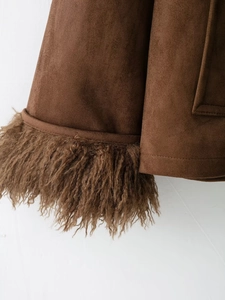 Detail of brown faux suede jacket sleeve with curly faux shearling fur trim on white background