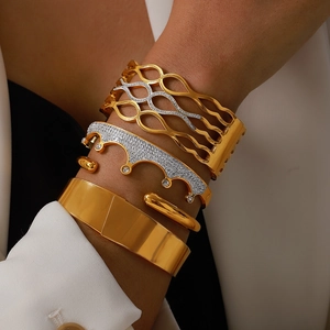 Elegant gold and silver bangles with crown and geometric details on woman's wrist