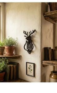 Close-up detail of vintage cast iron deer head door knocker with textured metal finish