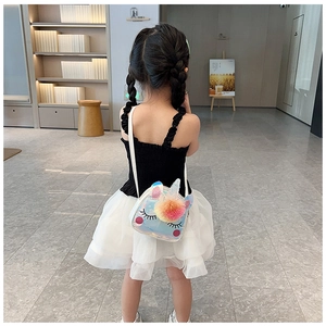 Borsa pranzo unicorno con paillettes e pon pon colorati indossata da bimba in gonna bianca