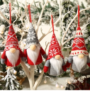 Hanging knitted Christmas gnomes with LED lights on white branches for festive decor