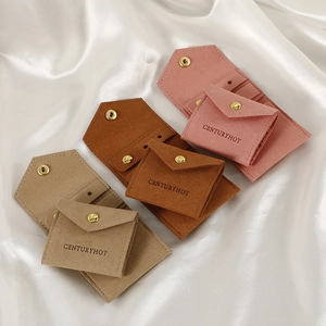 Microfiber jewelry rolls with gold snaps in pink and brown on silk fabric background