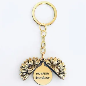 Macro shot of sunflower keychain showing You Are My Sunshine engraving on inner metal plate