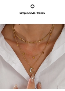 Detail view of a triple-layered gold stainless steel necklace with star and moon charms