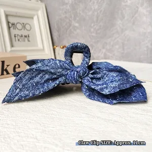 Detailed view of 11cm denim blue bow hair claw clip with white speckled texture