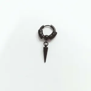 Macro view of matte black punk earrings with dragon relief and solid cone spike pendant