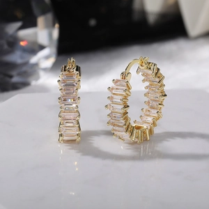 Close-up of gold plated hoop earrings featuring a row of sparkling rectangular cubic zirconia