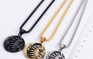 Detailed view of sun and moon relief pendants in black, gold, and silver finishes