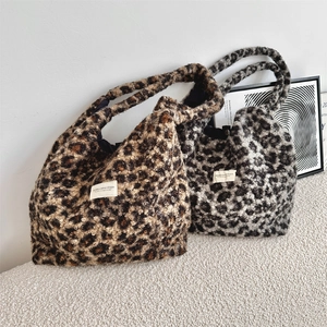 Detail of leopard print plush tote bags in brown and grey with soft faux fur texture