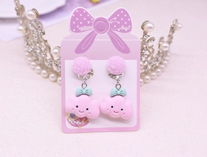 Detail of pink cloud clip-on earring for kids featuring a blue bow and soft pompom