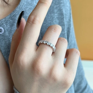 Close-up of a s925 silver eternity ring with sparkling round cubic zirconia on a finger