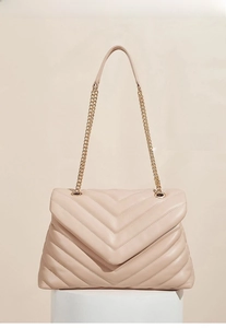 Detail of soft pink V-quilted handbag with gold chain and adjustable strap feature