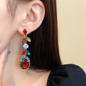 Close-up of elegant long drop earrings with multi-color rhinestones on a female model