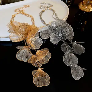 Elegant multi-strand layered necklace with large hollow floral pendant in gold and silver