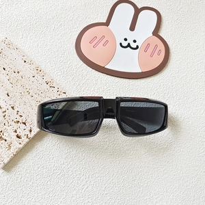 Close-up of black sport sunglasses for kids with Y2K wraparound frame and gray lenses