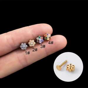 Detailed close-up of four flower-shaped stainless steel labret studs with zircon settings