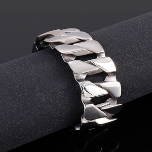 Detailed view of polished silver steel Cuban link chain bracelet on a cylinder
