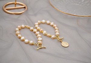 Close-up of baroque freshwater pearl bracelet with OT buckle and gold coin pendant