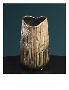 Close-up of golden electroplated ceramic vase with vertical ribbed texture and heart-shaped rim