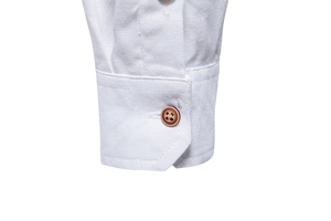 Close-up of white cotton shirt sleeve cuff with textured fabric and dark wood button