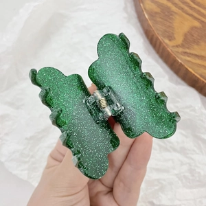 Sparkly green butterfly claw clip made of acrylic material for elegant hair styling