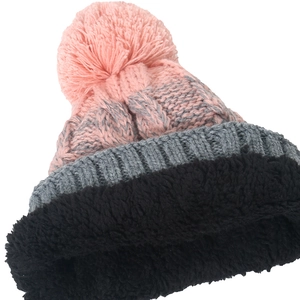 Detailansicht des dicken schwarzen Fleecefutter und des rosa Pompons an einer Strickmütze