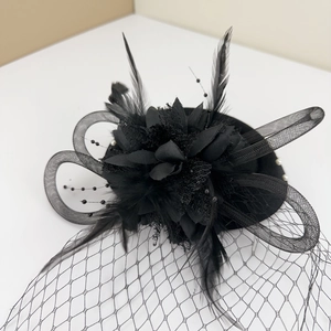Detail of vintage black mesh fascinator with delicate feathers and pearl accents